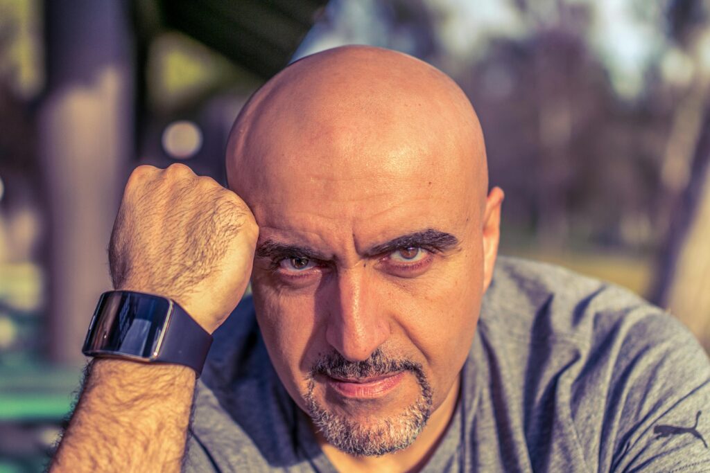 pexels photo 26970608 26970608 Bald man with smartwatch in an outdoor portrait setting, exuding confidence.